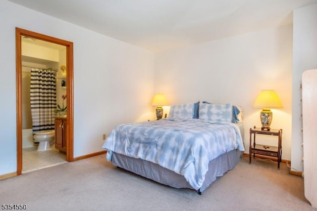 bedroom with carpet floors, baseboards, and ensuite bath