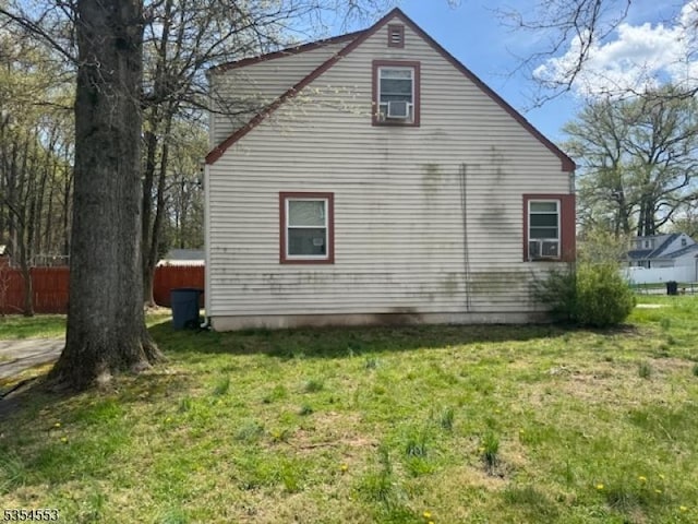view of property exterior featuring fence, a yard, and cooling unit