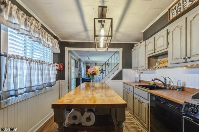 kitchen with crown molding, a sink, butcher block counters, and black appliances