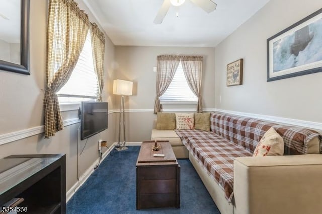 living room with dark carpet, a ceiling fan, and baseboards