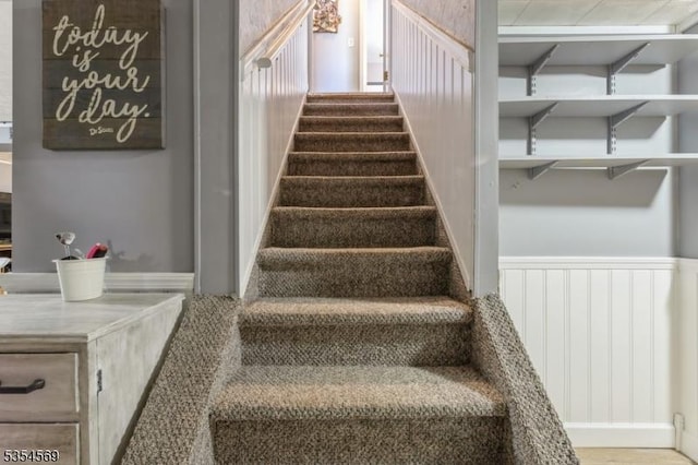 staircase featuring wainscoting