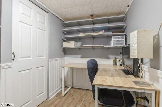 office featuring light wood-type flooring and a wainscoted wall