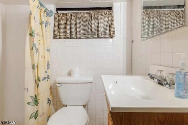 bathroom featuring toilet, a shower with curtain, tile walls, and vanity