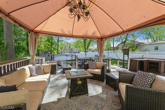 view of patio with an outdoor structure, outdoor lounge area, fence, a shed, and a gazebo