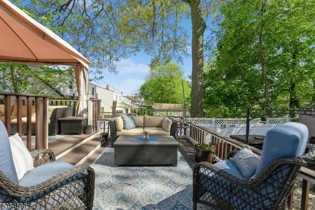 wooden deck with fence, a gazebo, outdoor lounge area, and a patio area