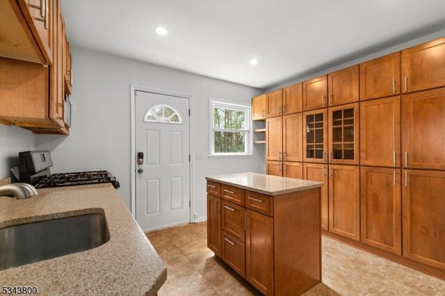 18 Lake Shore Dr, Parsippany-Troy Hills Twp, NJ 07034 - kitchen with brown cabinets, range with gas stovetop, a sink, and a kitchen island