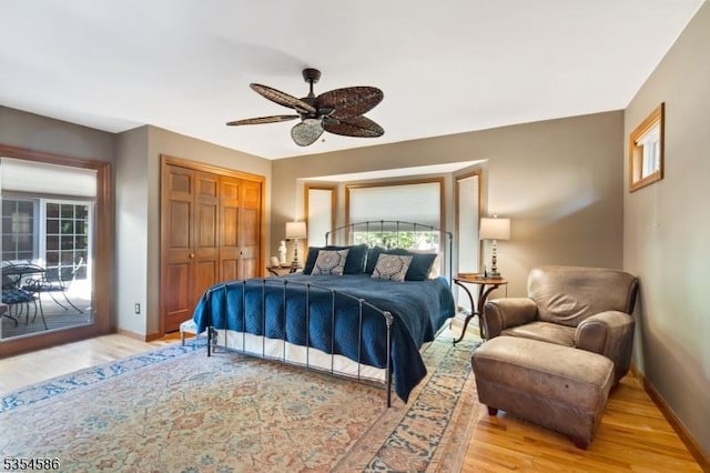 bedroom featuring baseboards, multiple windows, wood finished floors, and a closet