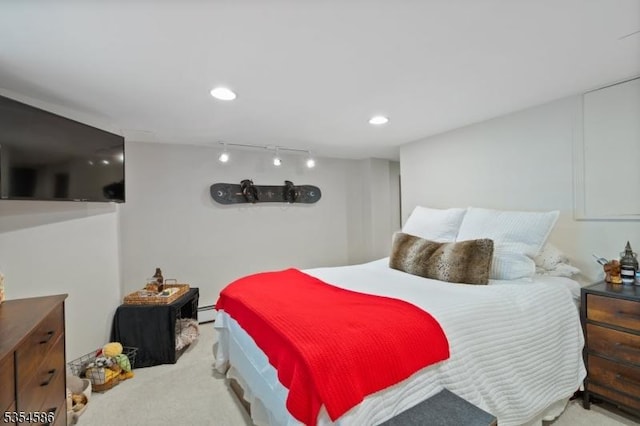 carpeted bedroom with recessed lighting, a baseboard heating unit, and track lighting