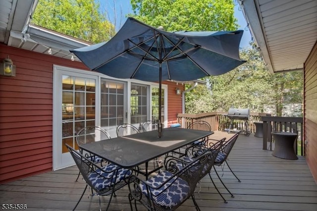 wooden terrace with outdoor dining space and a grill