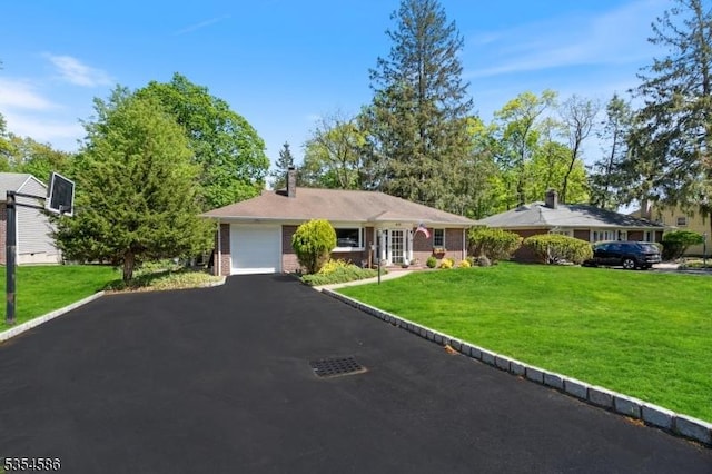 ranch-style home featuring brick siding, aphalt driveway, a chimney, and a front lawn