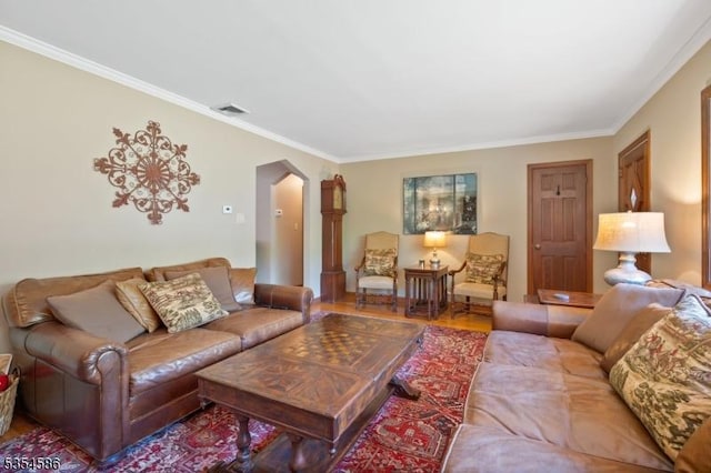living area featuring crown molding, arched walkways, visible vents, and wood finished floors
