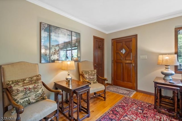 living area with crown molding, baseboards, and wood finished floors