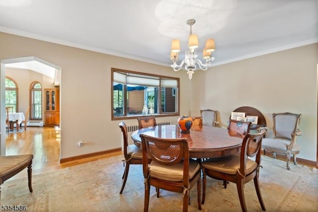 dining area featuring baseboards, ornamental molding, light wood finished floors, and a chandelier