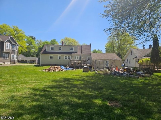 back of property featuring a lawn, fence, and a chimney