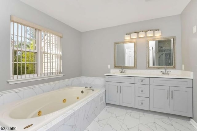 bathroom with a jetted tub, a sink, marble finish floor, and double vanity
