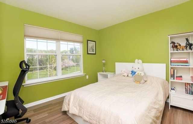 bedroom with baseboards and wood finished floors