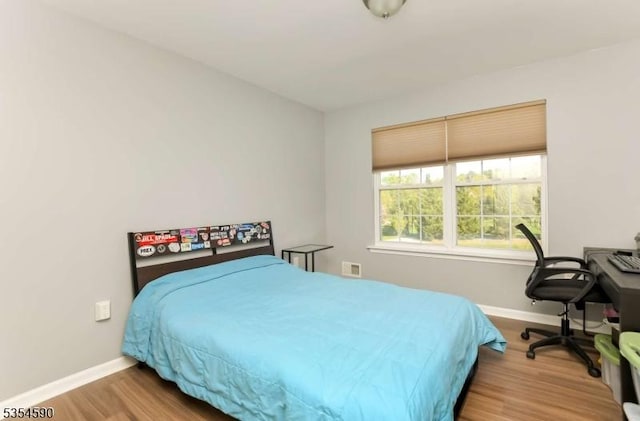 bedroom featuring baseboards and wood finished floors