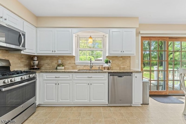 kitchen featuring a sink, white cabinets, light stone countertops, and stainless steel appliances