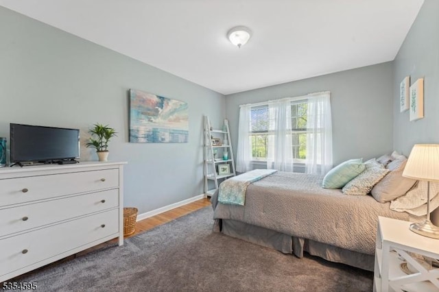 bedroom with baseboards and wood finished floors