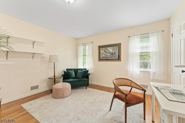 sitting room with baseboards, wood finished floors, and visible vents