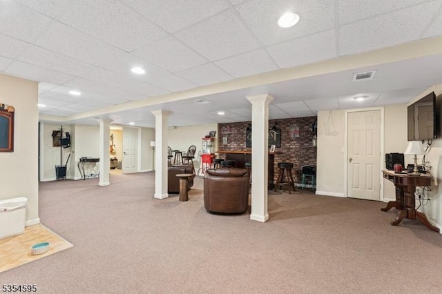 finished basement featuring carpet floors, baseboards, a paneled ceiling, and visible vents