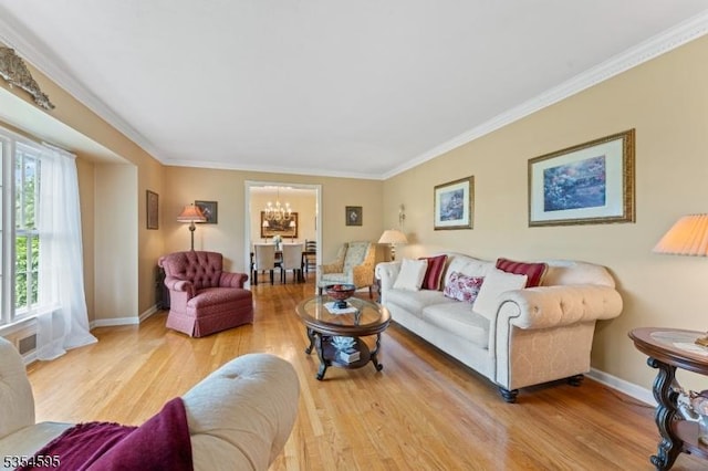 living room with baseboards, ornamental molding, wood finished floors, and a chandelier