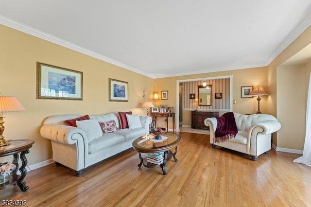living room featuring crown molding, baseboards, and wood finished floors