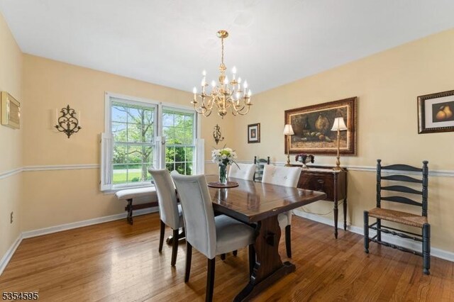 dining room featuring baseboards, an inviting chandelier, and wood finished floors