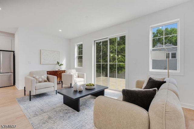 living area with plenty of natural light, light wood-type flooring, recessed lighting, and baseboards