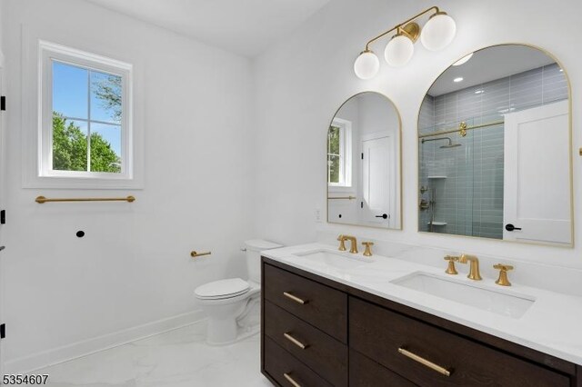 full bathroom with a stall shower, toilet, marble look tiles, double vanity, and baseboards