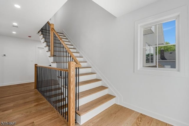 stairway featuring wood finished floors, baseboards, and recessed lighting