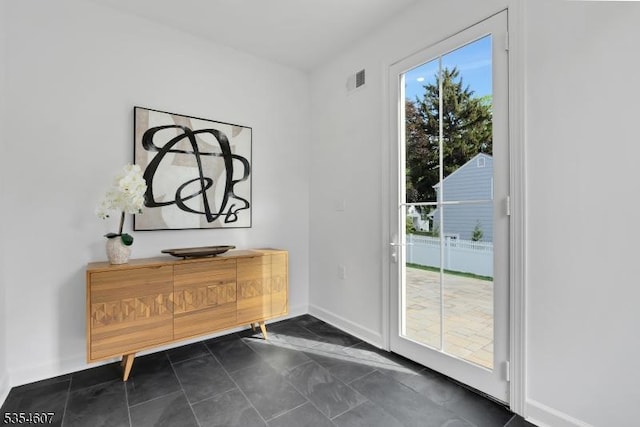 doorway to outside featuring baseboards