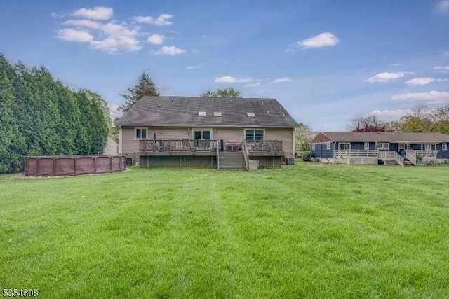 34 Hunter St, Roxbury Twp, NJ 07876 - back of house featuring a deck, an outdoor pool, and a yard