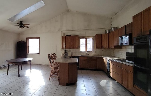 12 Ridge Rd, Andover Twp, NJ 07860 - kitchen with decorative backsplash, a breakfast bar, light countertops, light tile patterned floors, and black appliances
