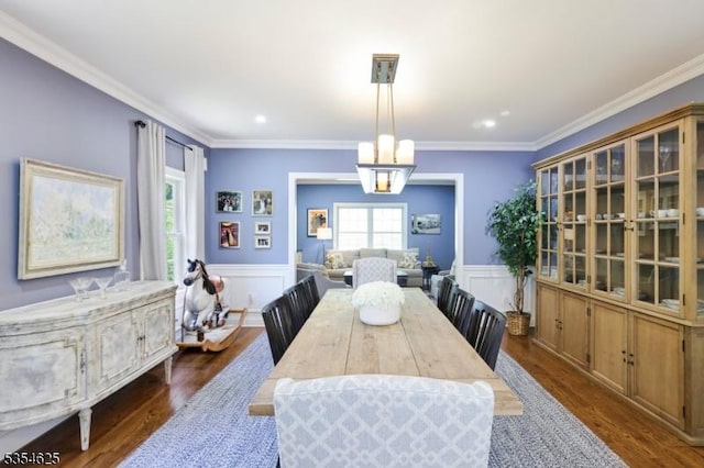 dining room featuring crown molding, dark wood-style flooring, recessed lighting, a wainscoted wall, and a notable chandelier