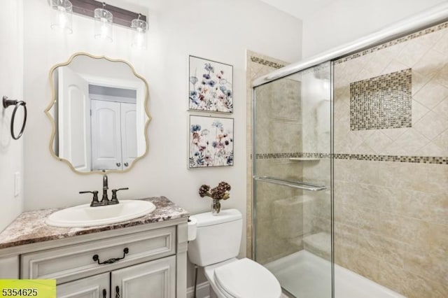 full bath featuring vanity, toilet, and a stall shower