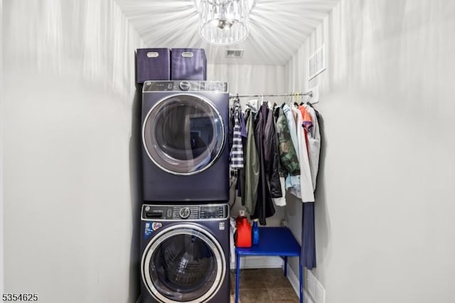 clothes washing area with laundry area, tile patterned floors, baseboards, and stacked washer / drying machine