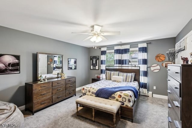 bedroom with a ceiling fan, baseboards, and light colored carpet