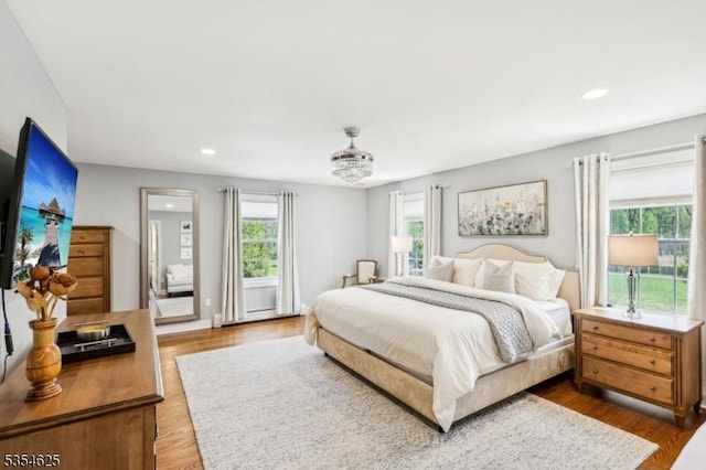 bedroom featuring recessed lighting, multiple windows, and wood finished floors