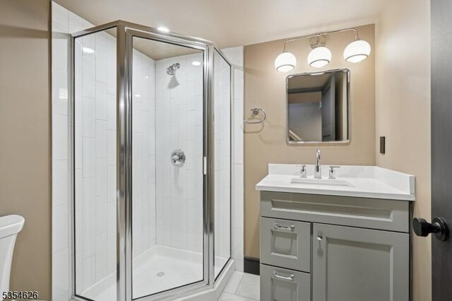bathroom with toilet, a shower stall, and vanity