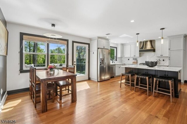 dining room with a healthy amount of sunlight, recessed lighting, baseboards, and light wood finished floors
