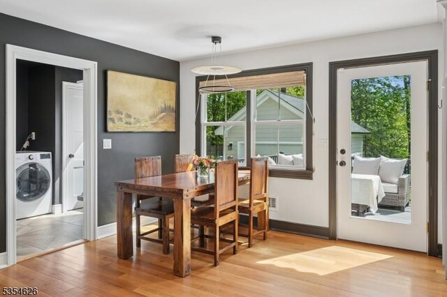 dining space with baseboards, washer / dryer, and light wood-style floors