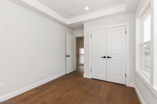 553 Thoreau Ter, Union Twp, NJ 07083 - unfurnished bedroom with baseboards, a raised ceiling, dark wood-style flooring, and a closet