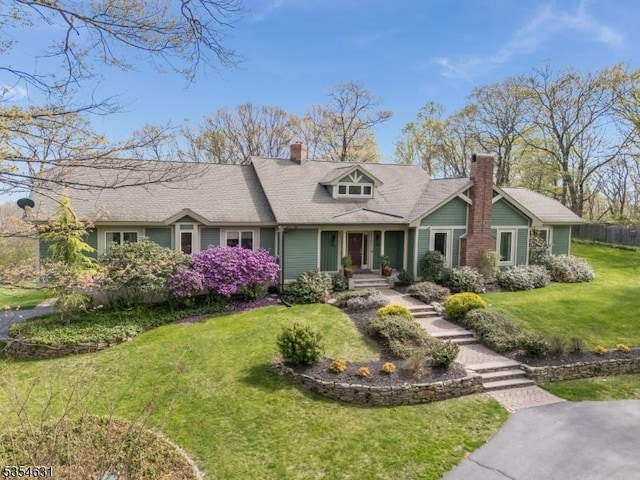 cape cod-style house featuring a chimney and a front yard
