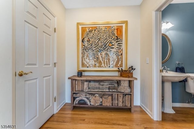 hall with baseboards and wood finished floors