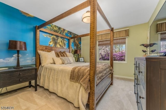 bedroom with baseboards, light colored carpet, and multiple windows