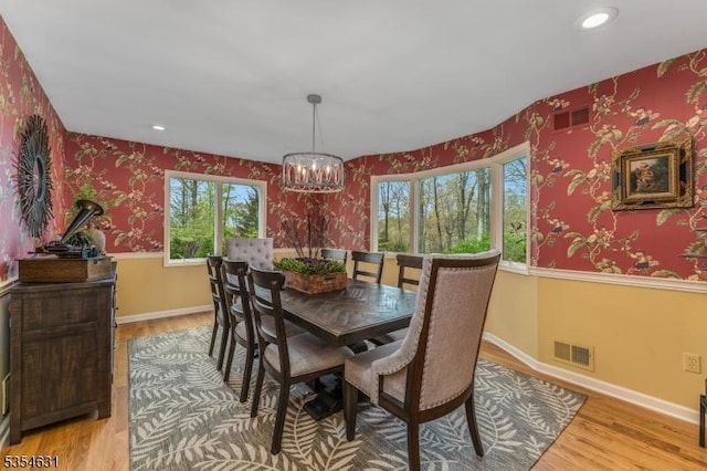 dining area with wallpapered walls, visible vents, a healthy amount of sunlight, and light wood finished floors