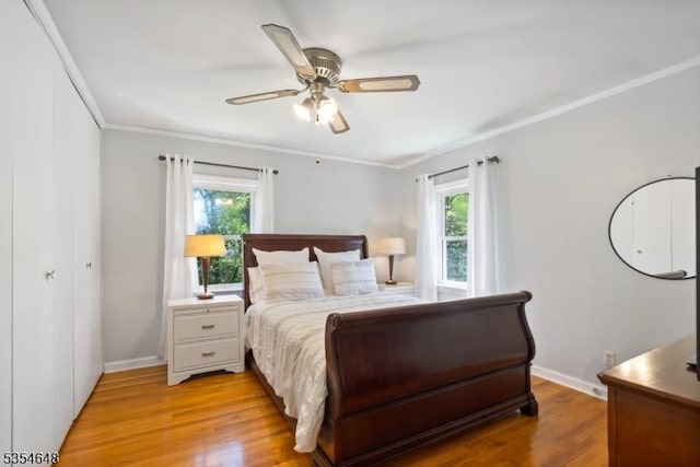 bedroom featuring light wood-style floors, multiple windows, and crown molding