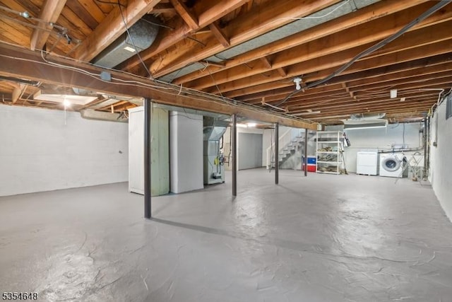 unfinished below grade area with heating unit, separate washer and dryer, and stairs