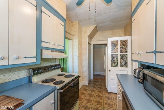 kitchen featuring white cabinets, ceiling fan, white appliances, wallpapered walls, and under cabinet range hood